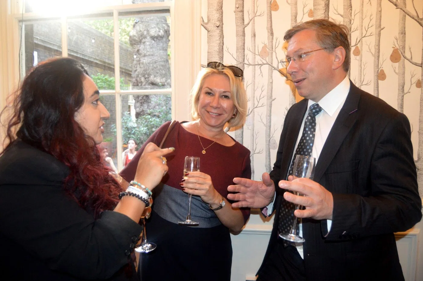 Guests talking by the birch-tree wallpaper